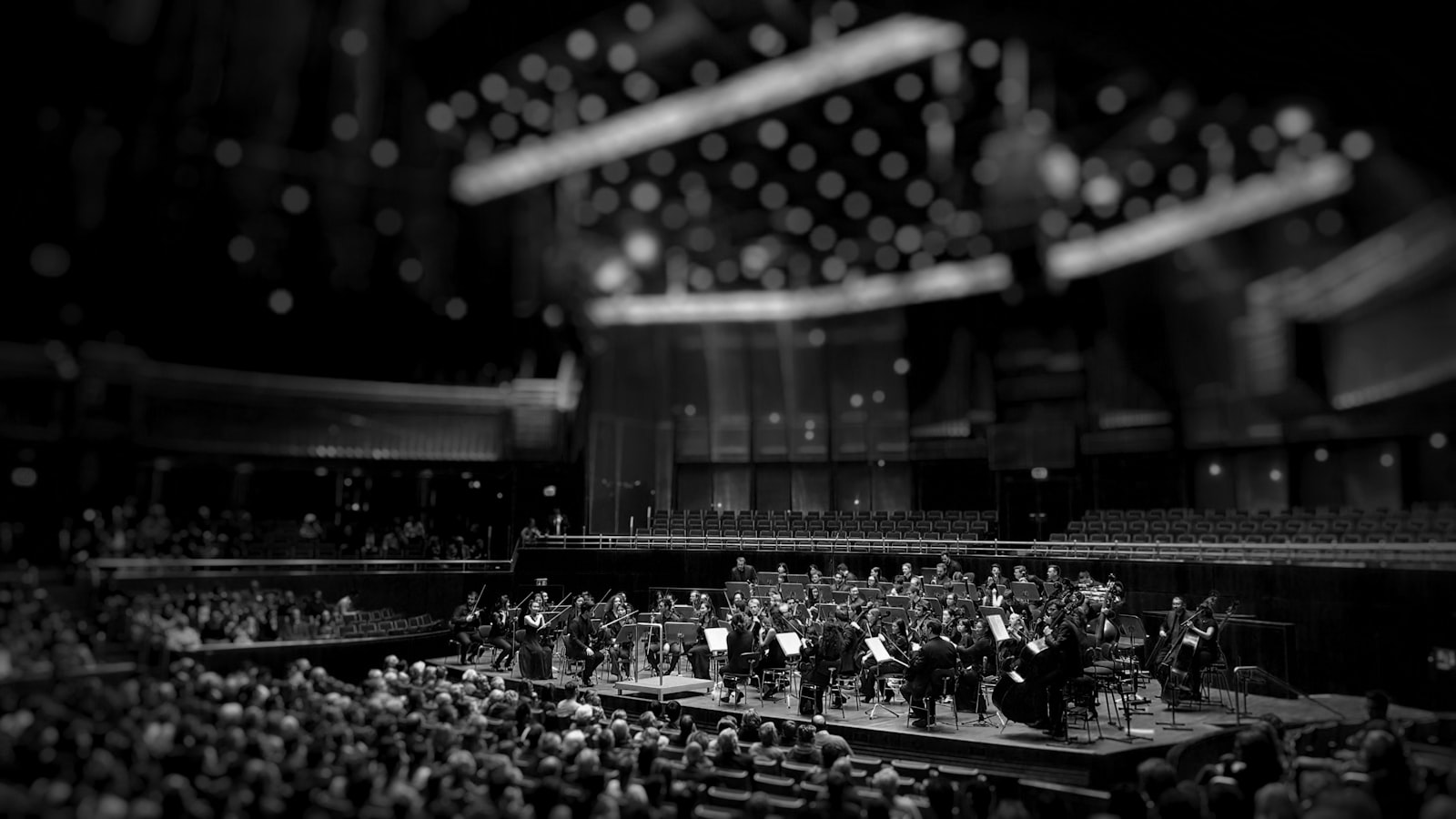 Schwarz-weiss-Aufnahme eines Orchesters auf der Bühne eines grossen Konzertsaals